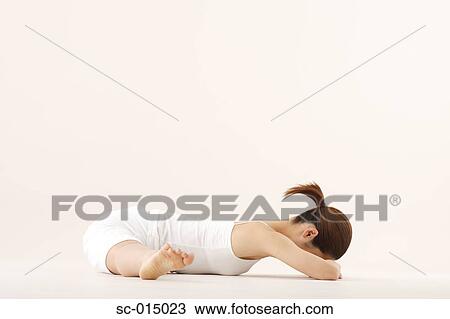 Stock Image - Young Asian woman in wheel pose. Fotosearch
