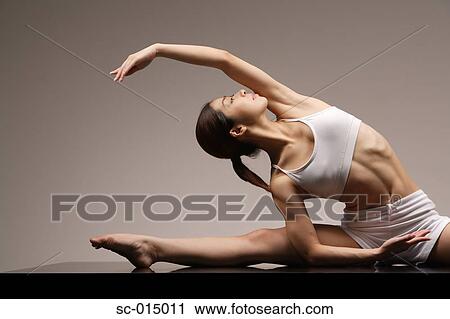 Stock Image - Young Asian woman in yoga position. Fotosearch
