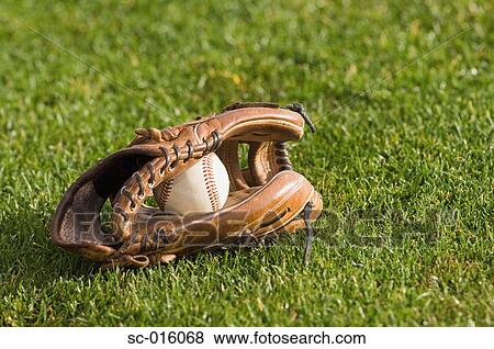 Baseball in a glove on grass View Large Photo Image Stock Photo - Baseball in a glove on grass. Fotosearch