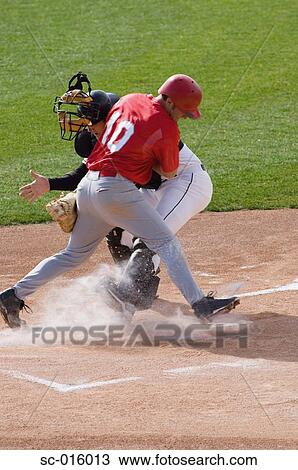 Stock Image - Baseball player charging home plate. Fotosearch