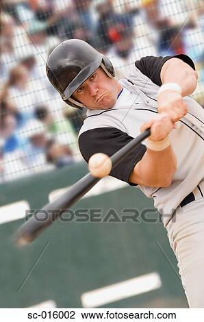 Stock Image - Baseball player hitting ball. Fotosearch
