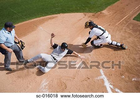 Stock Photo - Baseball player sliding into home plate. Fotosearch