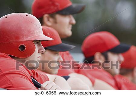 Stock Photograph - Baseball players looking on from the dugout. Fotosearch
