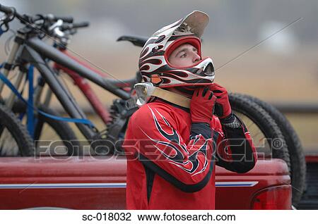 Stock Image - Mountain Biker Removing His Helmet. Fotosearch