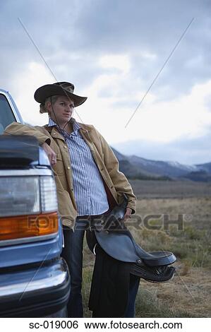 Stock Photograph - Cowgirl and her Saddle. Fotosearch