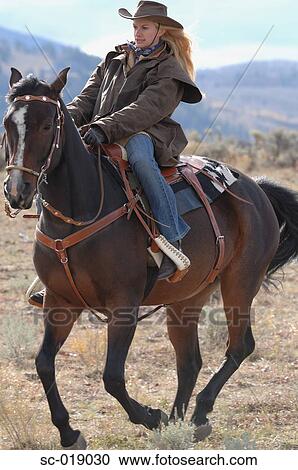 Stock Image - Cowgirl On her Horse. Fotosearch