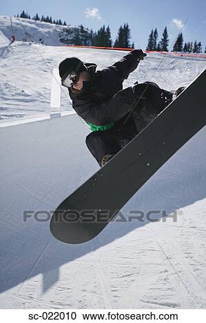 Stock Image - Snowboarder Riding a Half-Pipe. Fotosearch