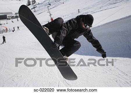 Stock Image - Snowboarder Riding a Half-Pipe. Fotosearch