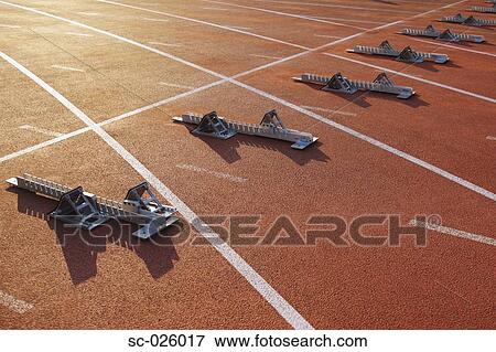 Stock Photo - Track and field starting blocks at starting line. Fotosearch