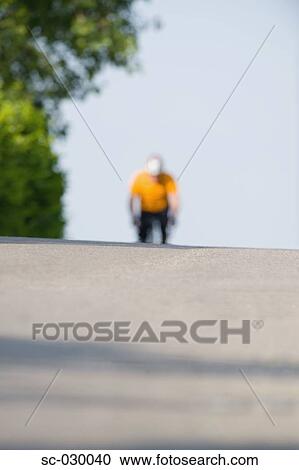 Stock Image - A cyclist cycling on road. Fotosearch