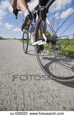 Stock Image - Close-up view of a cyclist pedaling. Fotosearch