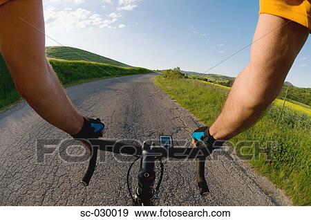 Stock Photo - Close-up view of hands on handle bars of a bicycle. Fotosearch