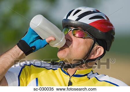 Stock Photography - Cyclist drinking water, close-up. Fotosearch