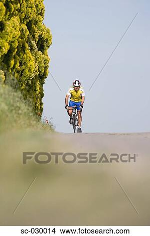 Cyclist riding bicycle, front view View Large Photo Image Picture - Cyclist riding bicycle, front view. Fotosearch