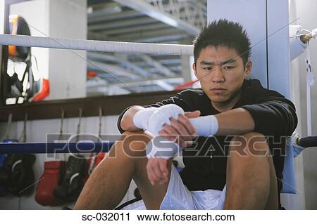 Stock Image - Japanese boxer sitting in Boxing ring. Fotosearch