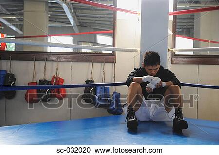 Stock Image - Japanese boxer sitting in corner of Boxing ring. Fotosearch