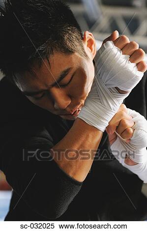 Japanese boxer tying bandage on his knuckles before fight View Large Photo Image Stock Photography - Japanese boxer tying bandage on his knuckles before fight. Fotosearch