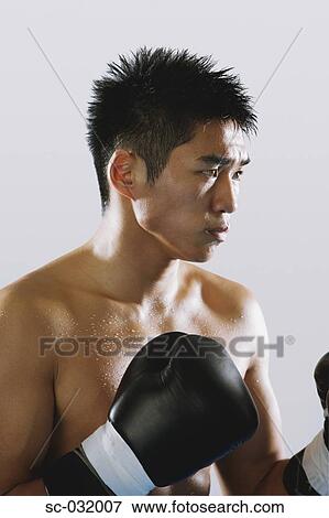 Stock Photo - Japanese boxer wearing gloves and sweating. Fotosearch