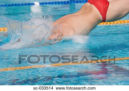 Picture - Australian swimmer diving for breaststroke competition swimming pool. Fotosearch