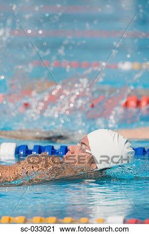 Stock Image - Swimmer doing backstroke in competition. Fotosearch