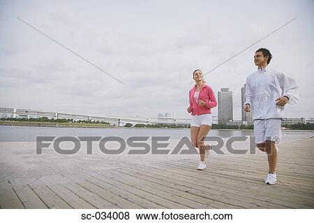 Young couple jogging on wharf View Large Photo Image Stock Photo - Young couple jogging on wharf. Fotosearch