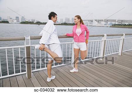 Young couple smiling and stretching legs on Bridge View Large Photo Image Stock Image - Young couple smiling and stretching legs on Bridge. Fotosearch