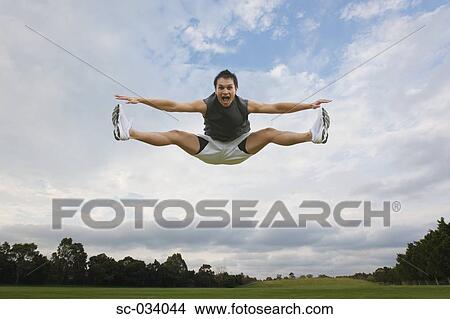 Picture - Young man jumping in the air. Fotosearch