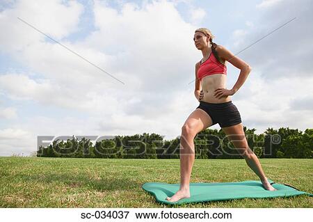 Stock Photo - Young Woman doing exercise on mat. Fotosearch