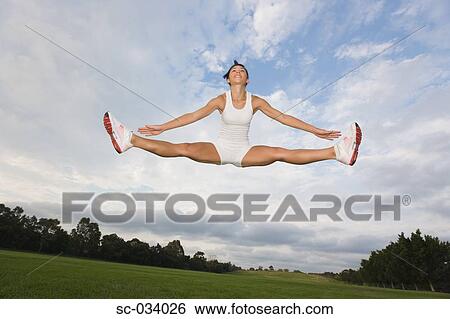 Stock Photograph - Young Woman jumping in the air. Fotosearch