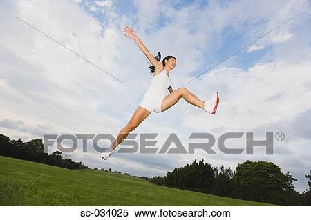 Stock Photography - Young Woman jumping in the air. Fotosearch