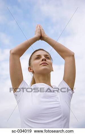 Stock Photo - Young Woman meditating in a tree pose. Fotosearch