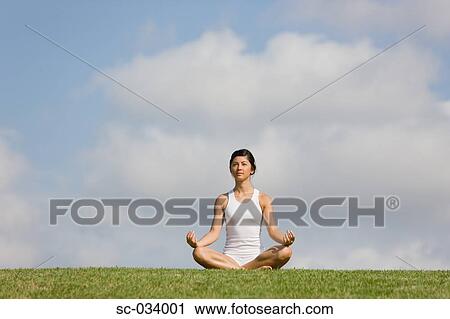 Young Woman sitting on grass in sukhasana position View Large Photo Image Stock Image - Young Woman sitting on grass in sukhasana position. Fotosearch