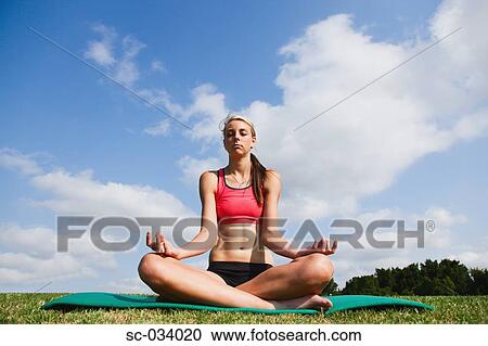 Young Woman sitting on mat in sukhasana position View Large Photo Image Stock Image - Young Woman sitting on mat in sukhasana position. Fotosearch