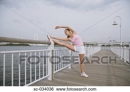 Young Woman stretching legs on Bridge View Large Photo Image Stock Photograph - Young Woman stretching legs on Bridge. Fotosearch
