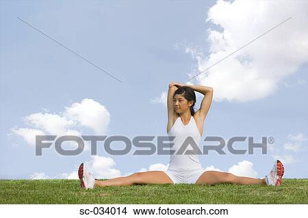 Young Woman Stretching Shoulders while Sitting on Grass View Large Photo Image Picture - Young Woman Stretching Shoulders while Sitting on Grass. Fotosearch