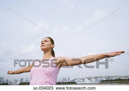 Stock Image - Young Woman with arms outstretched. Fotosearch