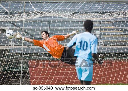 Stock Image - Goalkeeper diving for a save. Fotosearch