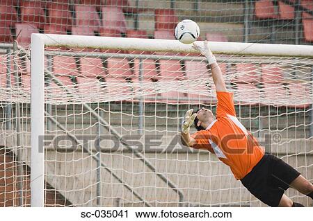 Stock Image - Goalkeeper diving for a save. Fotosearch