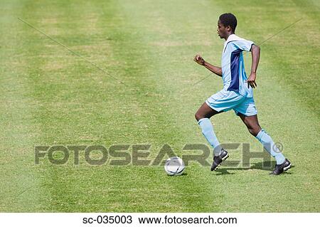 Soccer player running with ball View Large Photo Image Stock Image - Soccer player running with ball. Fotosearch