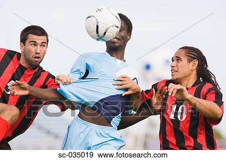 Three soccer players challenging for ball View Large Photo Image Stock Photo - Three soccer players challenging for ball. Fotosearch