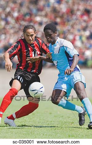 Two soccer players challenging for the ball View Large Photo Image Stock Image - Two soccer players challenging for the ball. Fotosearch