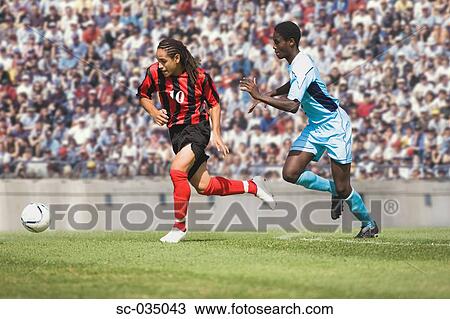 Stock Image - Two soccer players challenging for the ball. Fotosearch