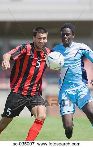 Two soccer players challenging for the ball View Large Photo Image Stock Photo - Two soccer players challenging for the ball. Fotosearch