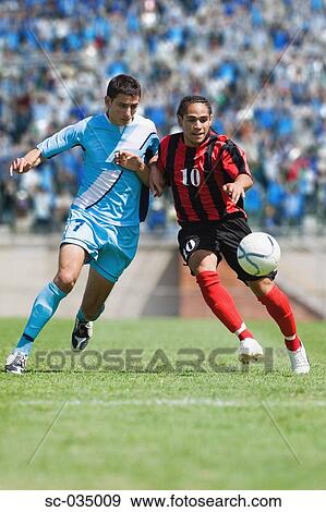 Two soccer players challenging for the ball View Large Photo Image Stock Photo - Two soccer players challenging for the ball. Fotosearch