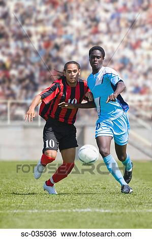 Stock Photograph - Two soccer players challenging for the ball. Fotosearch