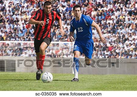Two soccer players challenging for the ball View Large Photo Image Stock Photography - Two soccer players challenging for the ball. Fotosearch