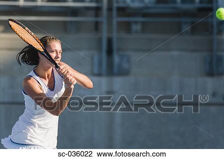 Stock Image - Female tennis player hitting backhand return. Fotosearch