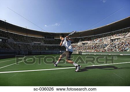 Tennis player hitting backhand return View Large Photo Image Stock Photograph - Tennis player hitting backhand return. Fotosearch