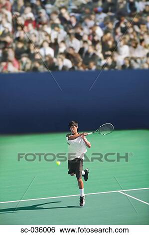 Stock Photograph - Tennis player hitting forehand return. Fotosearch