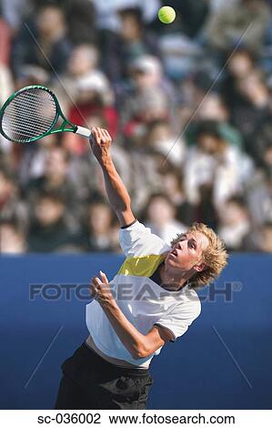 Stock Image - Tennis player serving. Fotosearch